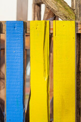 Blauer und gelber Bretterzaun aus Holz, Deutschland - 782038345