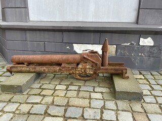Old rusty cannon near the building.