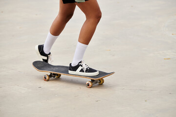 A young African American woman effortlessly rides a skateboard on a cement surface in a vibrant skate park.