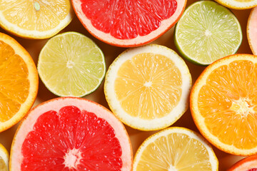 Fototapeta premium Different cut citrus fruits on beige table, flat lay
