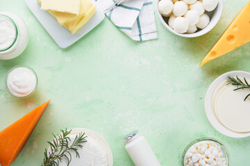 Dairy products or farm products. Fresh organic dairy products milk, cottage cheese, butter, cream, yogurt, sour cream and mozzarella on a light green slate, stone or concrete background. Top view.