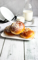 Fresh buns with milk. on a wooden background. dinner