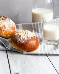 Fresh buns with milk. on a wooden background. dinner