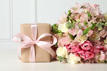 Happy Mother's Day. Gift box and bouquet of beautiful flowers on white table