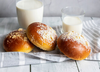 Fresh buns with milk. on a wooden background. dinner