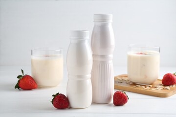 Tasty yogurt, oats and strawberries on white wooden table