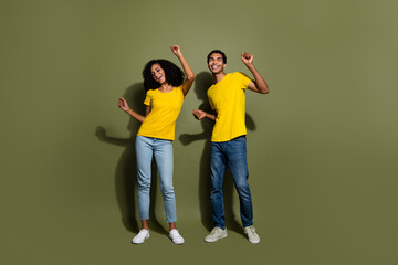 Fototapeta premium Full size photo of two young people dancing wear t-shirt isolated on khaki color background