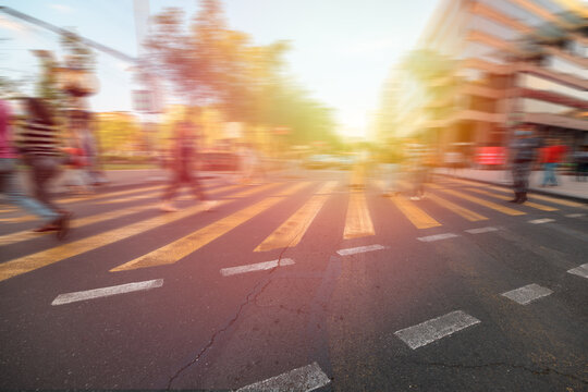 Crossing area, yellow lines, people crossing the road blurred, stock photo