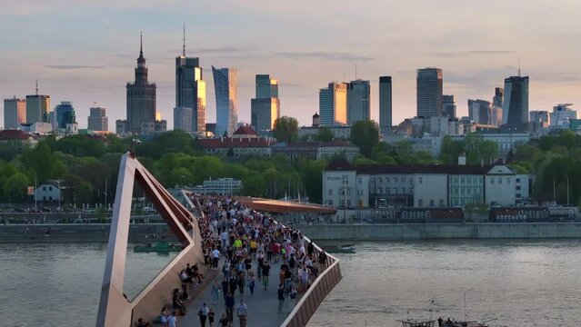 Warszawa, Poland - April 9, 2024: The panoramic view of downtown Warsaw boasts a vibrant mix of monuments and modern skyscrapers, framed by the modern shape of the pedestrian and bicycle bridge