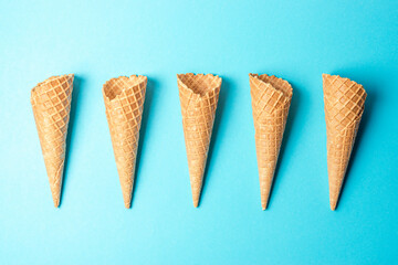 Various ice cream cones on blue background. Minimal summer concept.