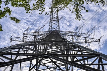 The towering electrical pole stood sentinel-like against the sky, its metal arms outstretched,...