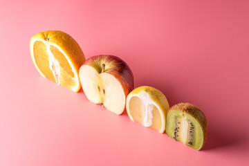 Creative composition with sliced fruits on pink background. Summer minimal concept.