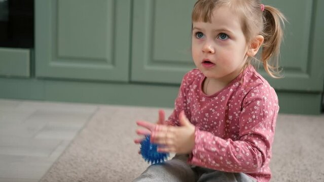 ute baby girl playing tactile knobby balls. Young child hand plays sensory massage ball. Enhance the cognitive, physical process. Brain development. Support for Children with ADHD, autism, fidgeting