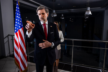 President of the USA during press conference. Positive American politician waves his hand and poses...