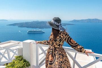 Beautiful woman enjoying view of Santorini island and Caldera in Aegean sea. Greece. - obrazy, fototapety, plakaty