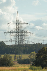 Multiple power pylons behind each other going through the field