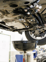 Engine oil change process. Used oil drain in lifted car