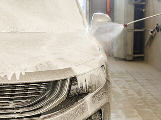 Car wash concept. Front view of suv covered with water droplet beading on hood bumper. Professional...