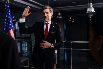 President of the USA during press conference. Positive American politician waves his hand and poses...