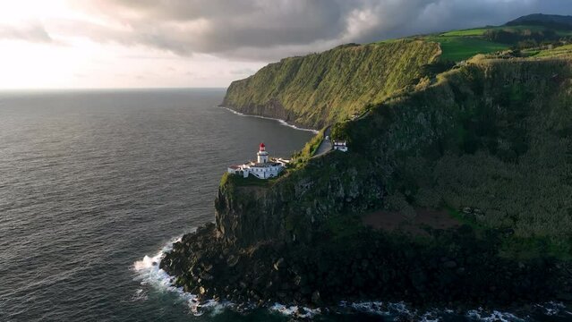 Aerial view of amazing Lighthouse Farol Ponta do Arnel in atlantic ocean, 4k footage. Sao Miguel, Azores, Portugal.