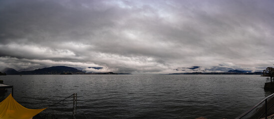 panorama of lake Maggiore on a rainy day with heavy low clouds covering part of the coast