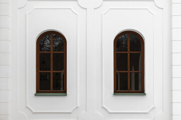 Classical windows with arches and decorative elements in white wall