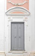 Closed gray wooden door in white pink wall, background photo texture - 782084157