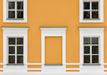 Decorated yellow wall with windows in white frames