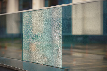 Damaged fence with broken glass, proterty damage. Cracked glass section, broken terrace railings. Damaged glass balustrade. Broken guard rail on office terrace. Cracked glass panel. SELECTIVE FOCUS.