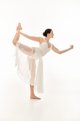A young woman in a flowing white dress gracefully balances against a clean white background.