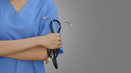 Close-up of a female doctor holding a stethoscope on a gray background.