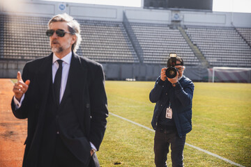 A photographer works at a press conference at the stadium, photographing a politician or the owner...
