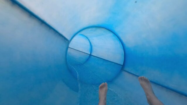 Water Slide, Teenager boy have fun in a closed slider at water Park. Fun on water. Enjoying water slider ride. Rider POV. Point of view in aqua park tube slide, having fun in aqua park with camera