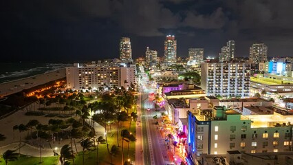 Aerial time Lapse of Miami Beach, Florida Nightlife at Night with colorful lights, clouds, people, and cars.