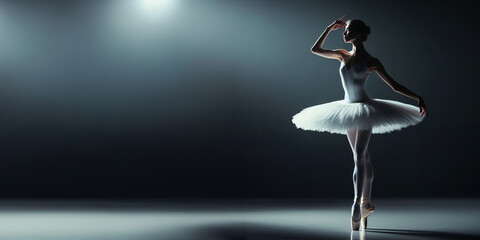 Against the backdrop of a dimly lit stage, a ballerina's silhouette emerges, her poised form exuding an air of serenity and grace, as if transported to a world of pure elegance, free space for text