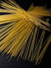 Scattered dry spaghetti on a black background. High quality photo