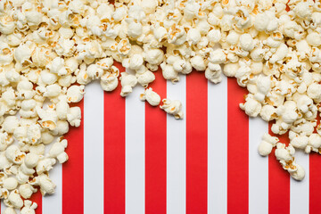 Flat lay composition with popcorn border and copy space on red and white stripes background.