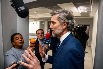 Irritated politician refuses to give interview for the TV press and quickly walks in corridor of...