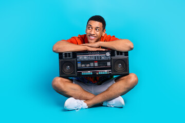 Full size portrait of nice young man hold boombox look empty space summer holiday isolated on blue...