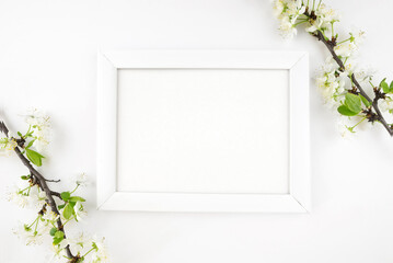 white wooden photo frame and branch with flowers on white