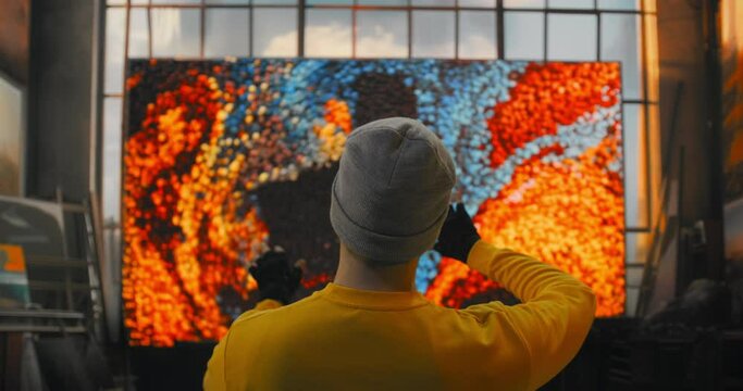 New York City, USA - April 2024 - A Man In A Yellow Shirt Is Painting A Large Window With Colorful Images Graffiti Wall Video Art Motion Graphics