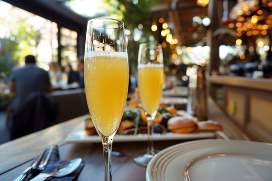 Mimosas served in champagne glasses, amidst a bustling brunch spot in resort.