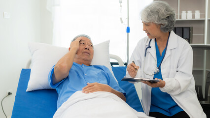 Senior Asian female doctor examining a sick old man in bed, female therapist caring for grandfather in nursing home Health care and health insurance