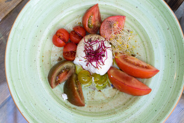 Fresh mozzarella and organic heritage tomato salad served for lunch at a Mediterranean beach...