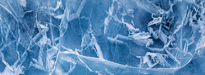 Abstract background of natural winter ice surface. Panoramic wide view from above of ice texture of frozen Baikal Lake. Natural pattern of crack lines, blue and white spots. Flat lay, banner, mock up