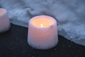 Candles lit in snow vessels.