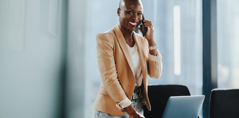 Portrait of a woman smiling and speaking on a smartphone in office - 782137183