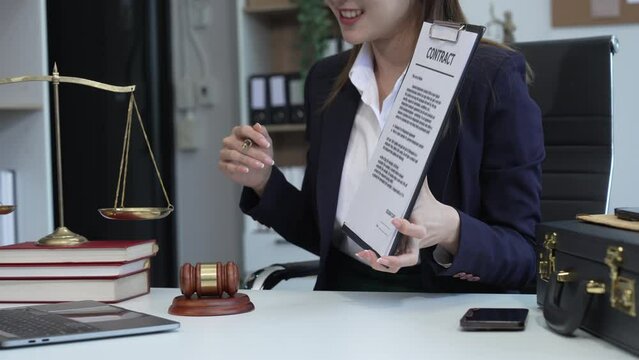 Asian legal compliance, faculty of law, legal counseling office, a female lawyer reads contract, advising on legal matters.clients, ensuring agreements align with laws and regulations, sign a contract