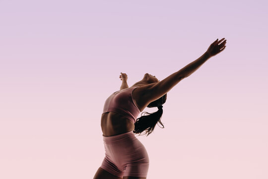 Fit ballerina displaying athletic movement in a studio silhouette