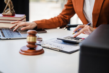 In Asian legal compliance,  legal counseling office, a female lawyer reads a contract, advising on legal matters. clients, ensuring agreements align with laws and regulations, using calculator